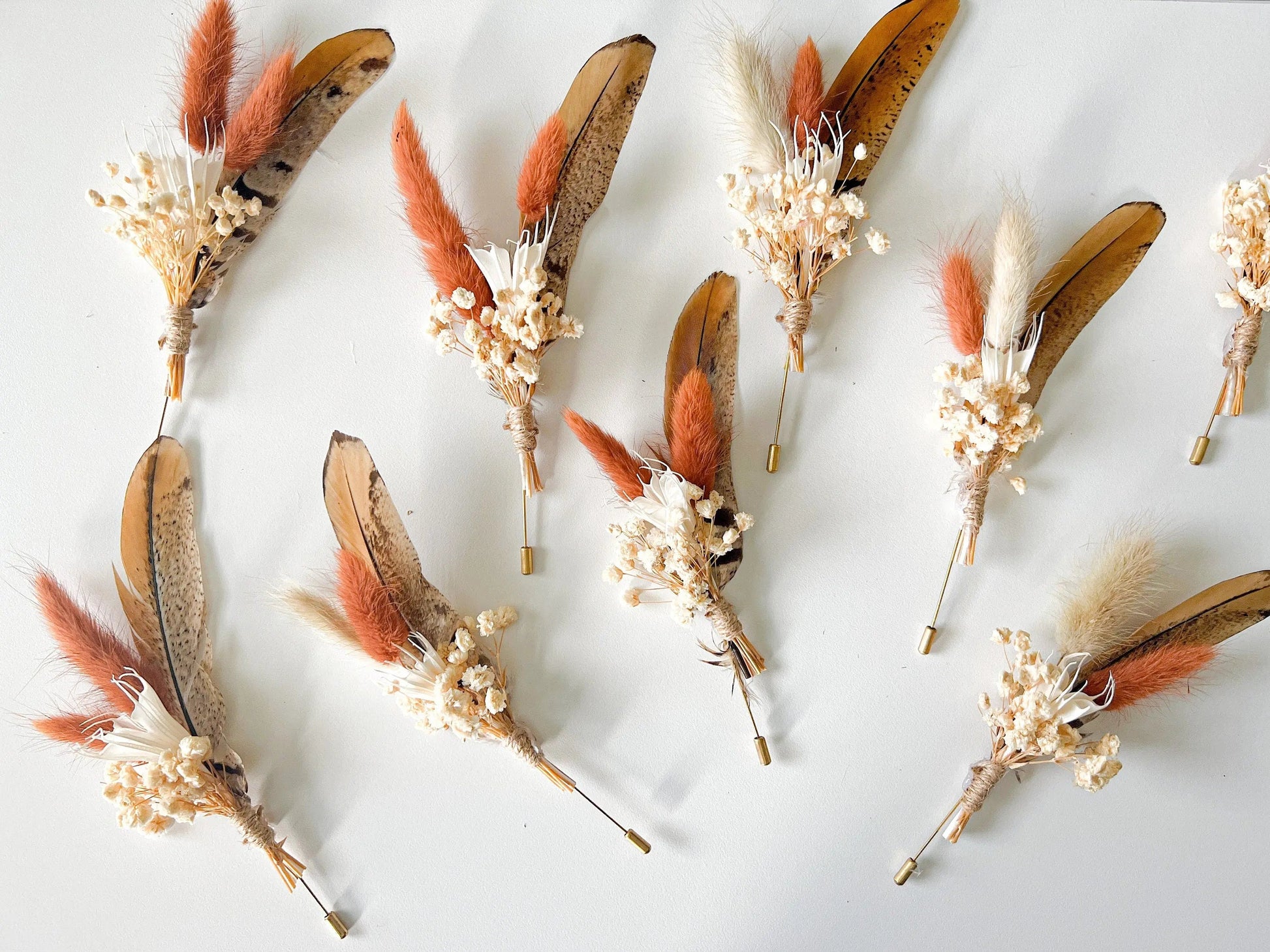 Groom boutonniere with feather and dried wildflowers in boho style